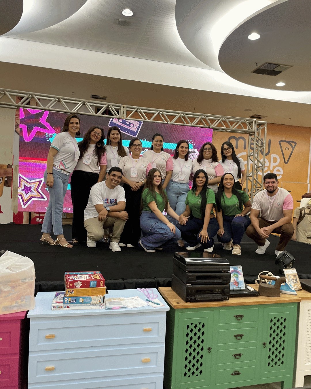 Equipe da Clínica CLIPS reunida no palco durante o evento Conectando Gerações no Rio Tapajós Shopping